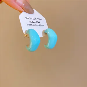 Détail de créoles en émail bleu clair en forme de losange avec tiges en argent S925
