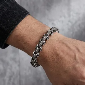 Detailed close-up showing a vintage punk style dragon bone bracelet on a man's wrist