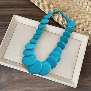 Collana con perle turchesi tonde piatte in stile dopamina su vassoio espositivo