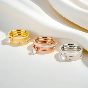 Detailed view of gold, rose gold, and silver stainless steel rings with zircon stones