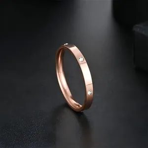 Close-up of a elegant rose gold stainless steel ring featuring embedded clear zircon stones