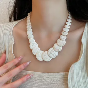 Primo piano di una collana di perle bianche screpolate con perle tonde stile marmo