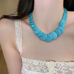 Vista dettagliata di una collana di perle tonde blu turchese indossata da una modella