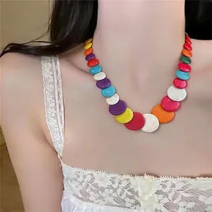 Primo piano di una vivace collana di perline circolari colorate in stile dopamina sul modello