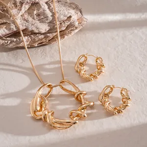 Détail de l'ensemble collier et boucles d'oreilles dorés à design géométrique