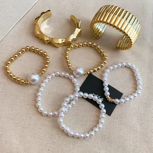 Detail shot of French-style pearl and gold-tone beaded bracelet and bangle set