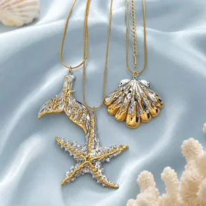 Close-up of gold and silver marine pendants featuring starfish, shell, and mermaid tail