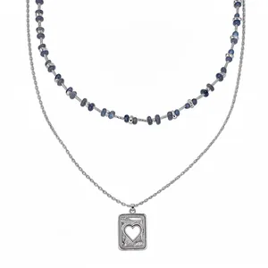Elegante dubbellaagse zilverkleurige ketting met blauwe kralen en een hart hanger