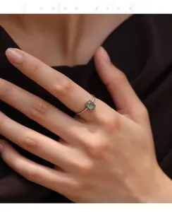 Close-up of a minimalist S925 sterling silver ring featuring a green moss agate stone