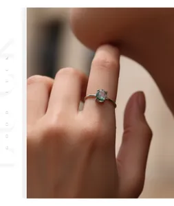 Close-up of S925 sterling silver ring with oval synthetic moss agate on finger