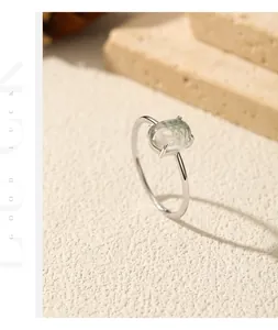 Macro detail of a 925 sterling silver ring with an oval synthetic moss agate gemstone.