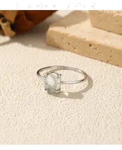 Detailed close-up of a minimalist S925 silver ring featuring an oval synthetic moss agate stone