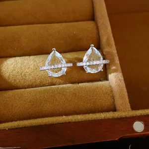 Vue détaillée de boucles d'oreilles en zircone poire dans un écrin en velours marron