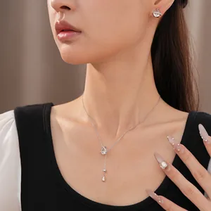 Vue détaillée d'un élégant ensemble collier et boucles d'oreilles en zircon goutte d'eau sur modèle.