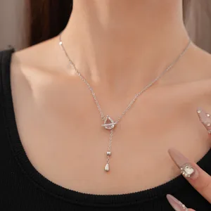 Élégant collier goutte en zircon argenté avec détail de bague planète sur un modèle
