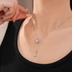 Détail du collier à pendentif goutte d'eau en zircon argenté porté par le modèle