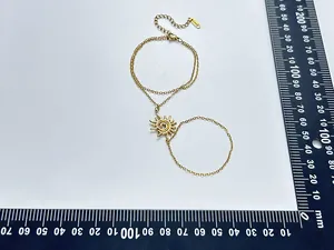 Vue détaillée du bracelet de doigt fleur de soleil en acier doré avec règle de mesure