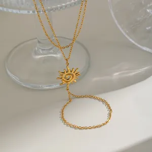 Vue détaillée de la breloque soleil dorée et de la chaîne double couche sur le bracelet.
