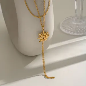Détail d'une chaîne de main en acier inoxydable doré avec un motif de soleil.