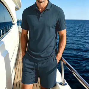 Men's luxury navy blue textured waffle knit polo shirt and matching shorts set on a yacht