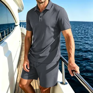 Detailed view of men's charcoal grey mesh polo shirt and shorts set on a yacht deck
