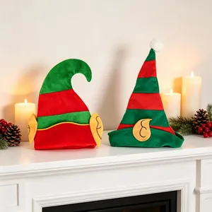 Bonnets de lutin de Noël rayés rouge et vert avec oreilles sur un manteau blanc