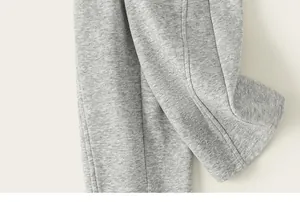 Vue détaillée du tissu gris chiné et des coutures d'un pantalon de jogging pour enfant