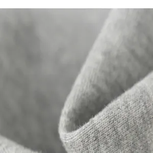 Vue macro montrant la texture douce du tissu en coton tricoté gris pour pantalons enfants