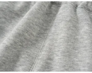 Vue rapprochée macro de la texture du tricot gris chiné doux et détails de couture.