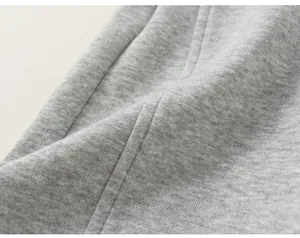 Gros plan sur le tissu en maille gris et les coutures de ce pantalon pour enfant
