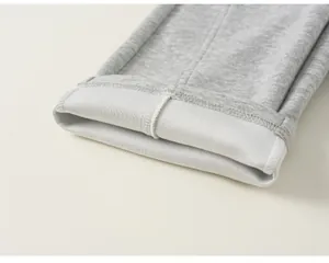 Détail rapproché du pantalon de jogging gris pour enfant montrant la texture du tissu