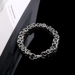Close-up detail of stainless steel men's bracelet with engraved Great Wall meander pattern