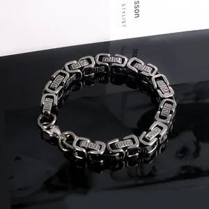 Detailed close-up view of a titanium steel men's bracelet with Greek key engraving