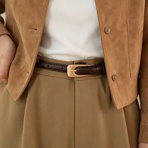 Gros plan d'une ceinture marron en similicuir avec boucle ardillon dorée mate élégante