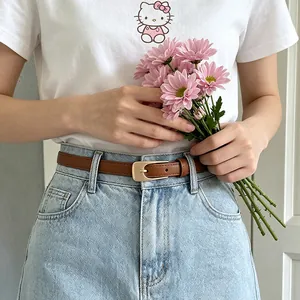 Gros plan d'une ceinture vintage en cuir PU marron avec boucle dorée sur un jean