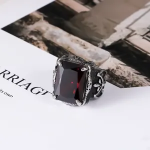 Close-up of vintage titanium steel men's ring with large rectangular red gemstone.