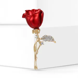 Exquisite close-up of a vibrant red rose brooch featuring a gold stem and crystal leaf