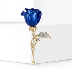 Close-up of elegant blue rose brooch with gold-tone stem and sparkling rhinestones
