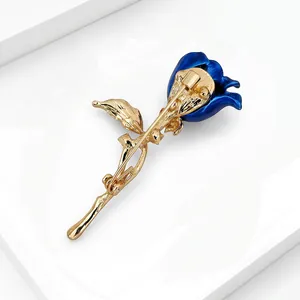 Back detail of an elegant gold and blue rose brooch showing the secure pin closure.