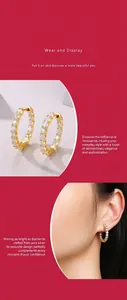 Détail de boucles d'oreilles créoles en or moissanite sur l'oreille d'un modèle asiatique.