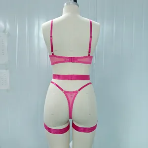 Detailed back view of vibrant pink mesh strappy lingerie set on a white fashion mannequin
