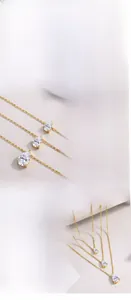 Detailed view of three pear-cut moissanite pendants on gold-plated silver chains.