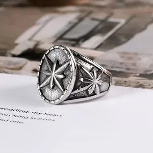 Gros plan sur une bague vintage en argent antique avec un motif d'étoile boussole détaillé.