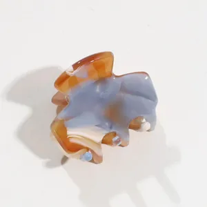 Detailed macro view of marbled acetate hair claw clip with blue and amber texture