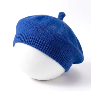 Detailed view of the blue knitted texture on a solid color baby beret hat