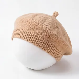 Detailed macro view showing the soft knitted texture and ribbed hem of a beige baby beret