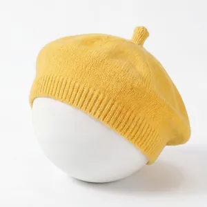 Detail view of a yellow knitted baby beret showing soft cotton texture and knit pattern