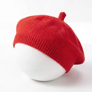Close-up view of red knitted baby beret hat on white mannequin head
