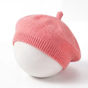 Detailed view of a soft pink knitted baby beret hat displayed on a white mannequin head.