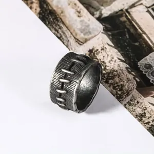 Macro view of vintage stainless steel ring with unique stitched pattern and distressed finish